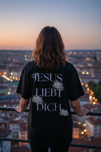 Frau am Aussichtspunkt trägt schwarzes Jesus Liebt Dich Oversized T-Shirt