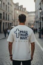 Mann trägt weißes Pray Trust Wait Oversized T-Shirt mit Kreuz
